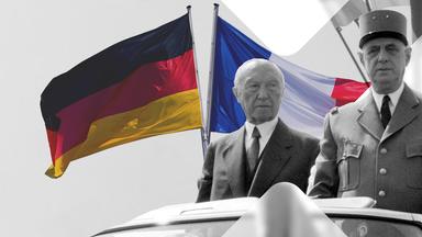 Adenauer und DeGaulle aufrecht stehend in einem Fahrzeug, im Hintergrund die deutsche und die französische Flagge 