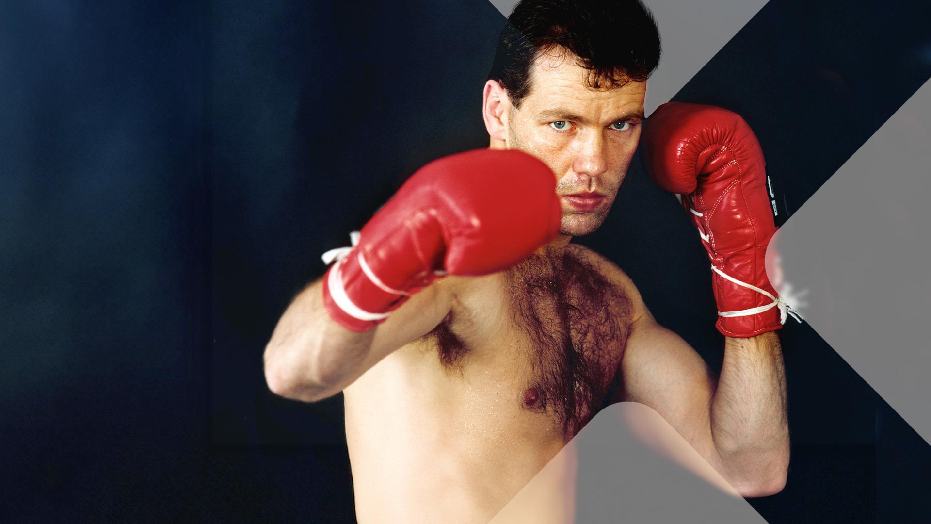 Henry Maske mit Boxhandschuhen vor schwarzem Hintergrund 