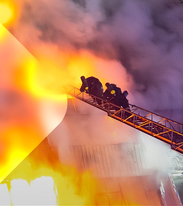 Ein brennendes Wohnhaus in der Ukraine, Feuerwehrleute auf einer Drehleiter.