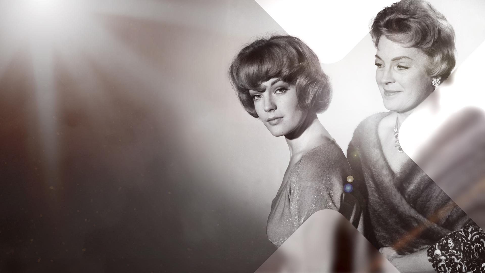 Romy und Magda Schneider auf der rechten Bildseite. Romys Mutter Magda steht hinter ihr und schaut ihr über die Schulter, während Romy in die Kamera schaut. 