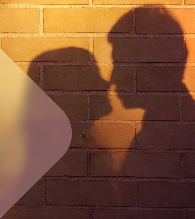 Der Schatten eines Paares wird an eine Mauer geworfen. 