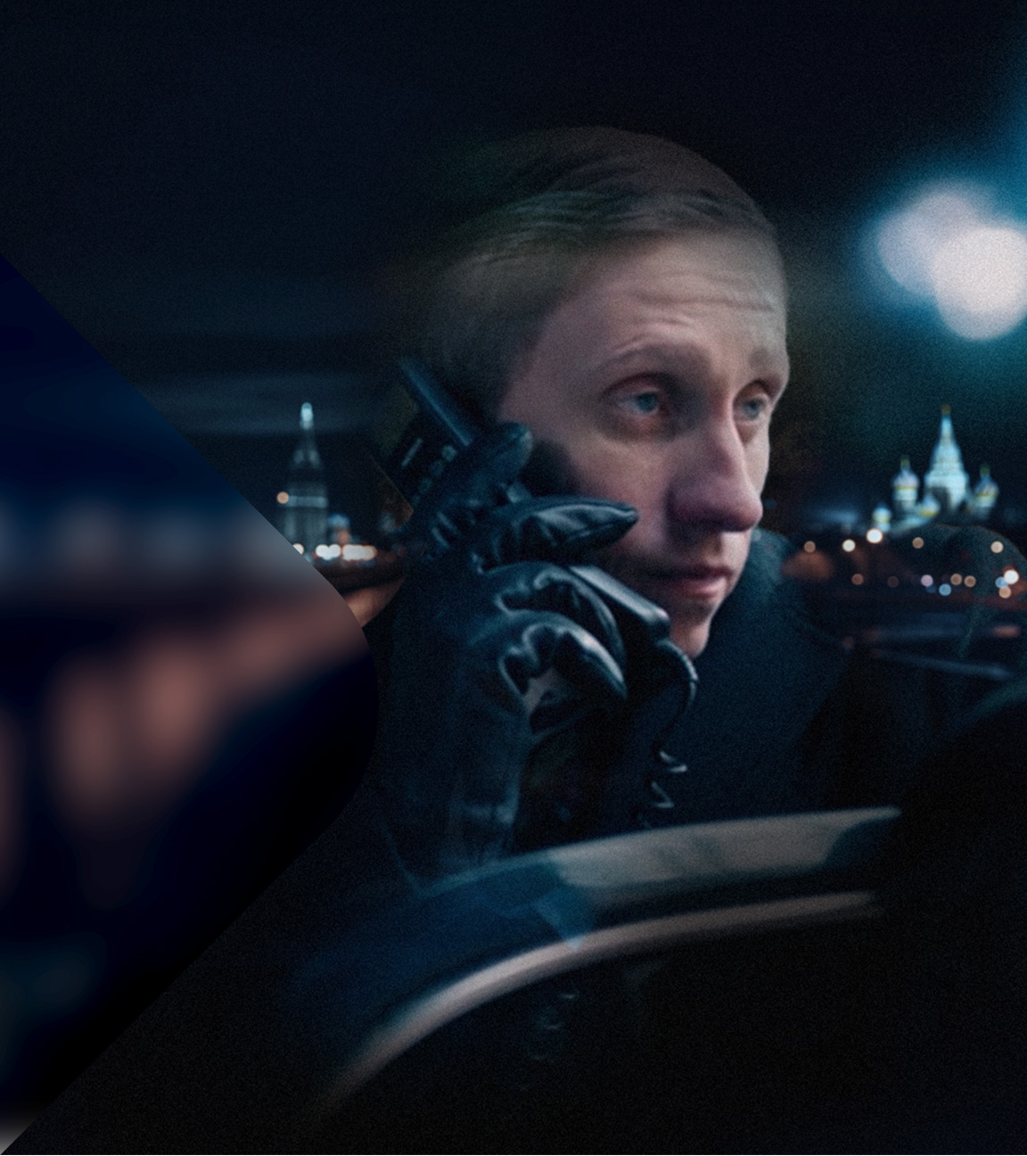 Putin Schauspieler im Profil mit Handy und Lederhandschuh vor dunklem Hintergrund.