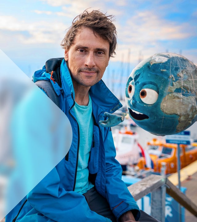 Uli Kunz vor Hafengelände mit personifizierter Erdkugel