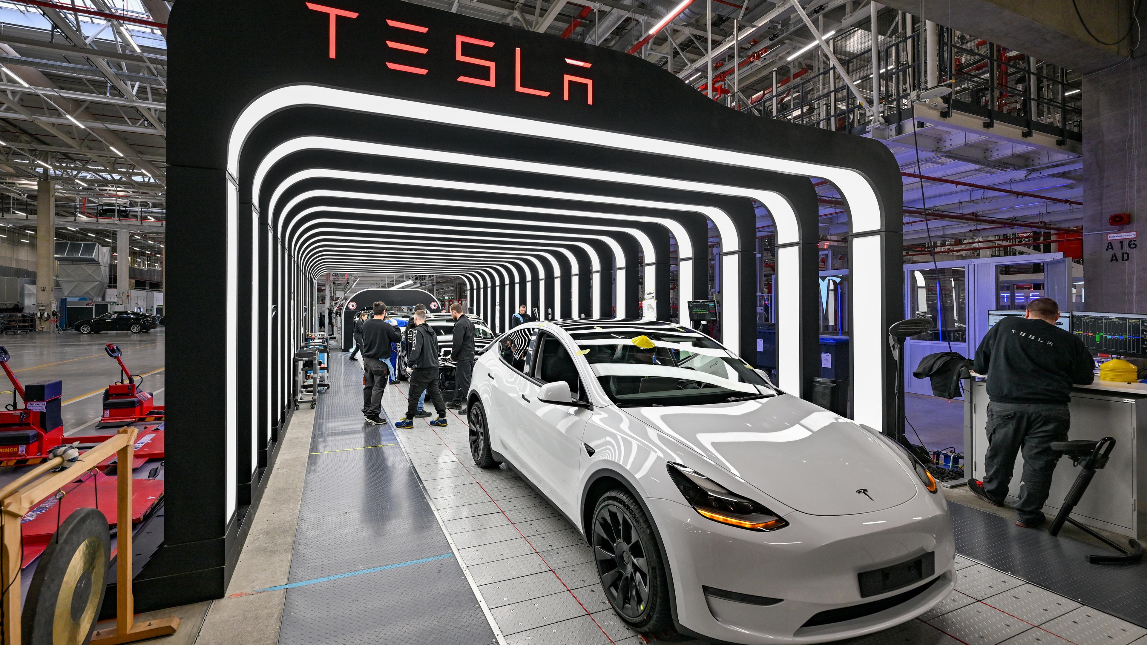 Mitarbeiter der Tesla-Gigafactory in Grünheide arbeiten an der Endkontrolle der fertigen Elektrofahrzeuge vom Typ Model Y. 