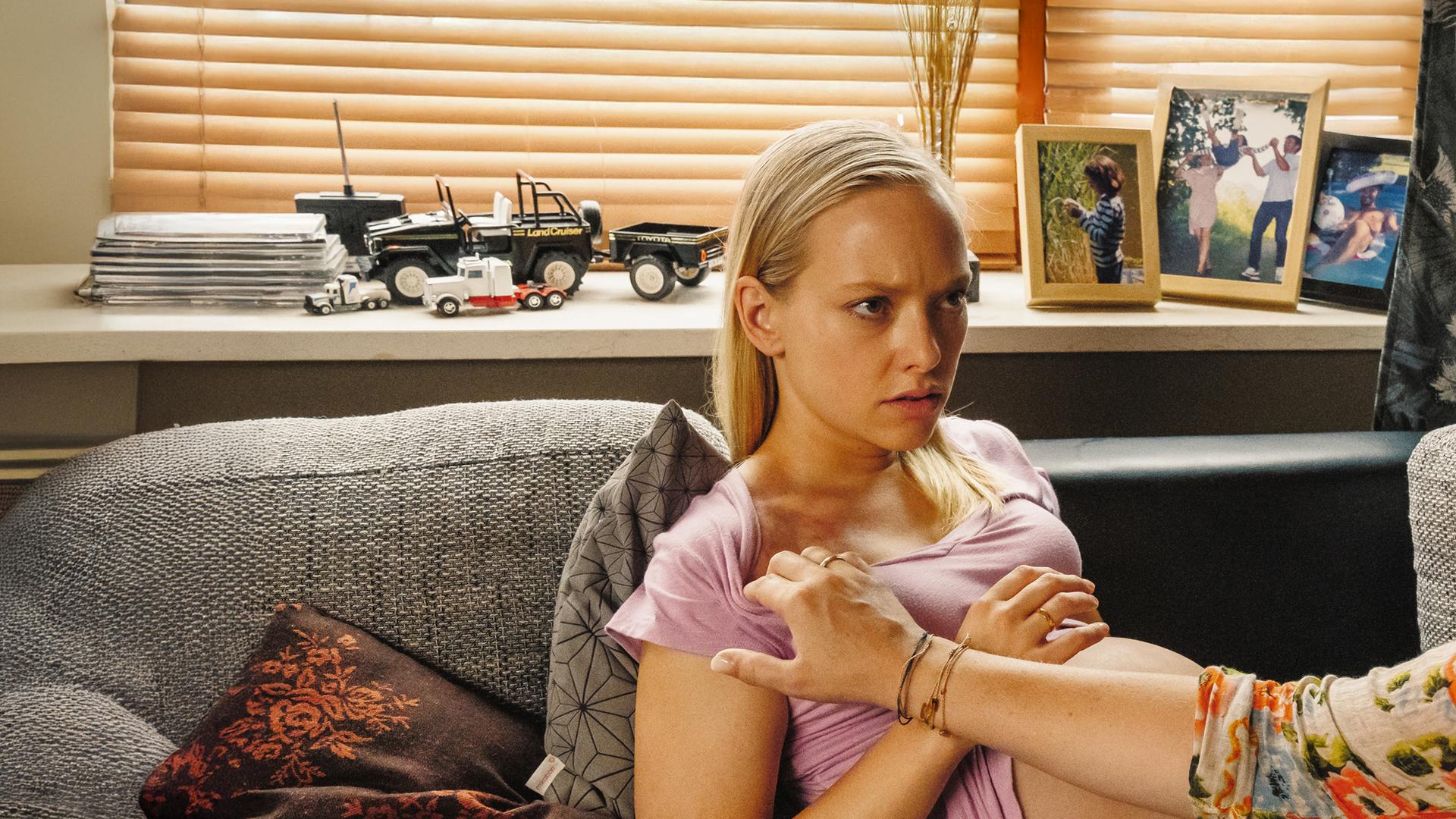 Auf einem Sofa liegt die hochschwangere Sandra Werner (Judith Neumann). Lena Lorenz (Judith Hoersch) sitzt vor ihr und entdeckt Hämatome am Hals.