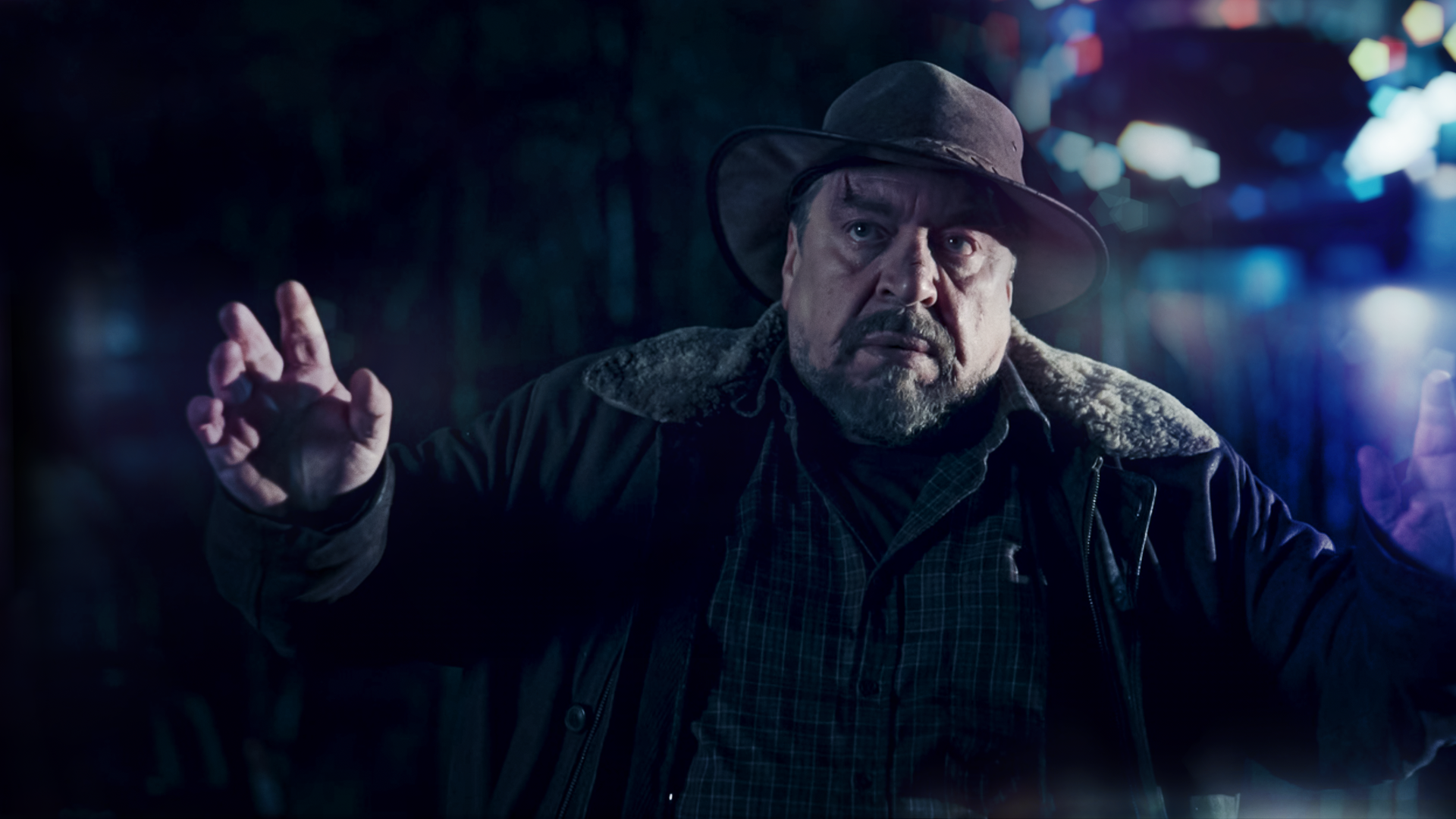 Wilhelm Grebe (Armin Rhode) steht mit erhobenen Händen an einer Straße.