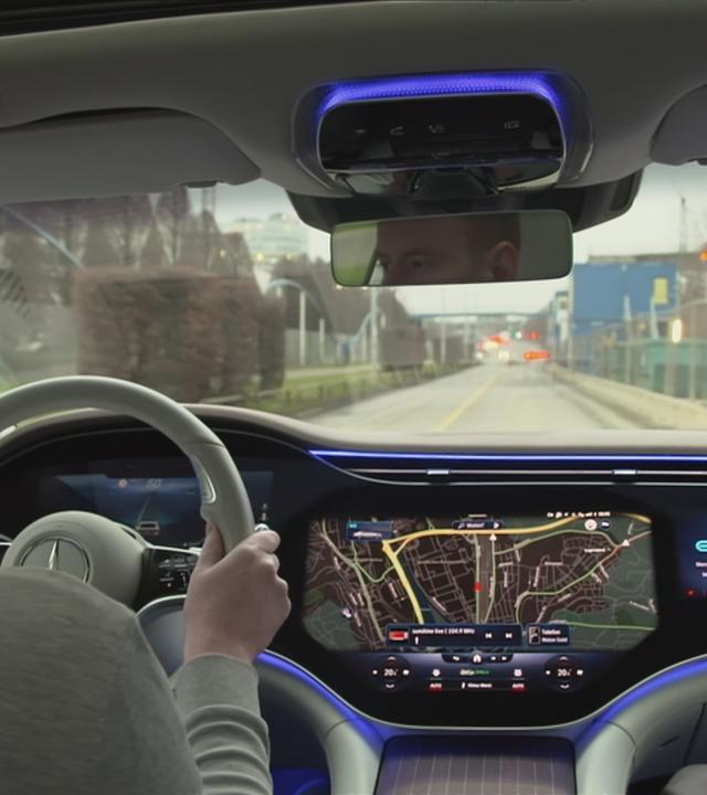 Mann hinter Lenkrad und sehr modernem Display