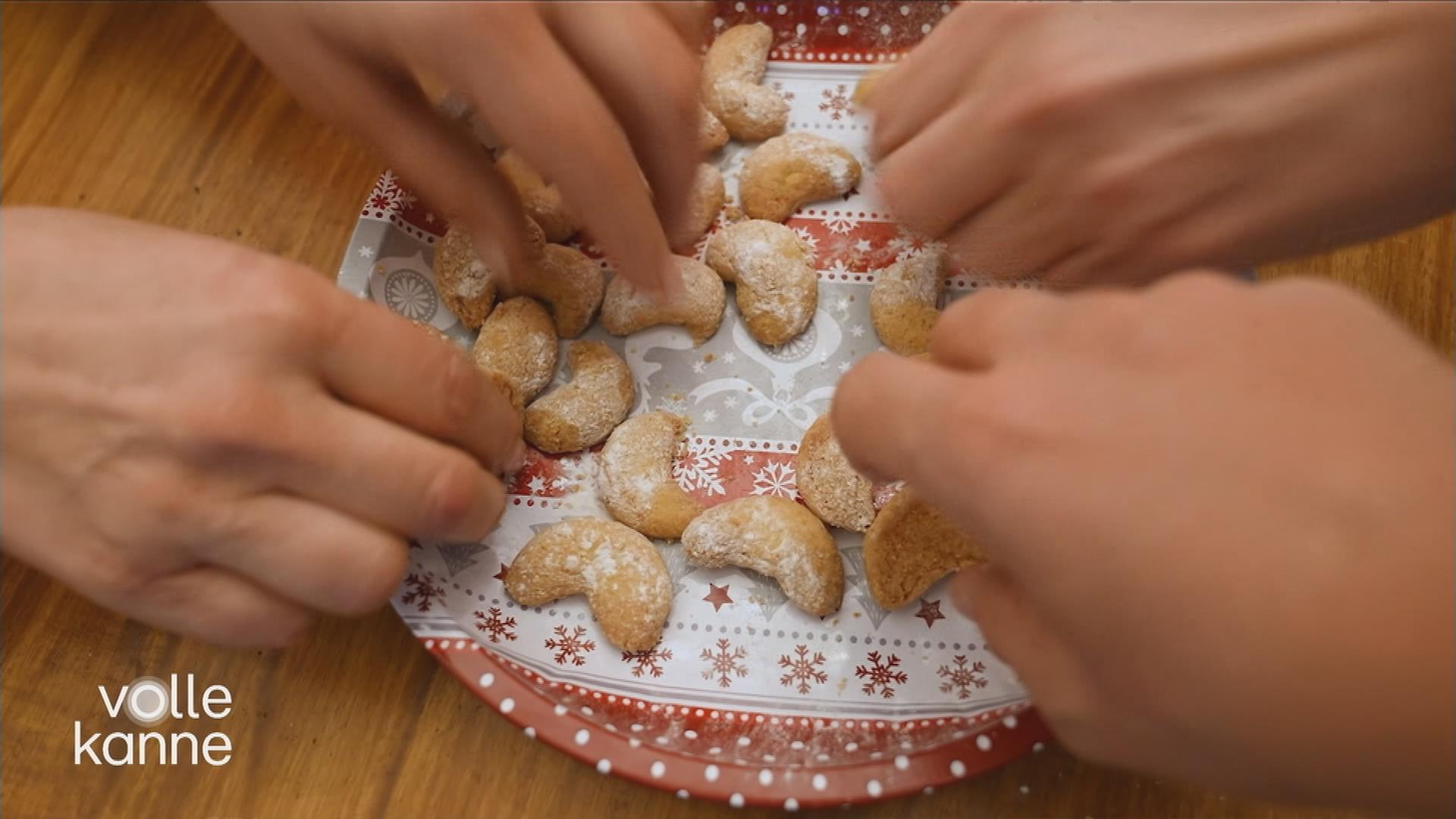 Plätzchen auf dem Teller, Hände greifen zu