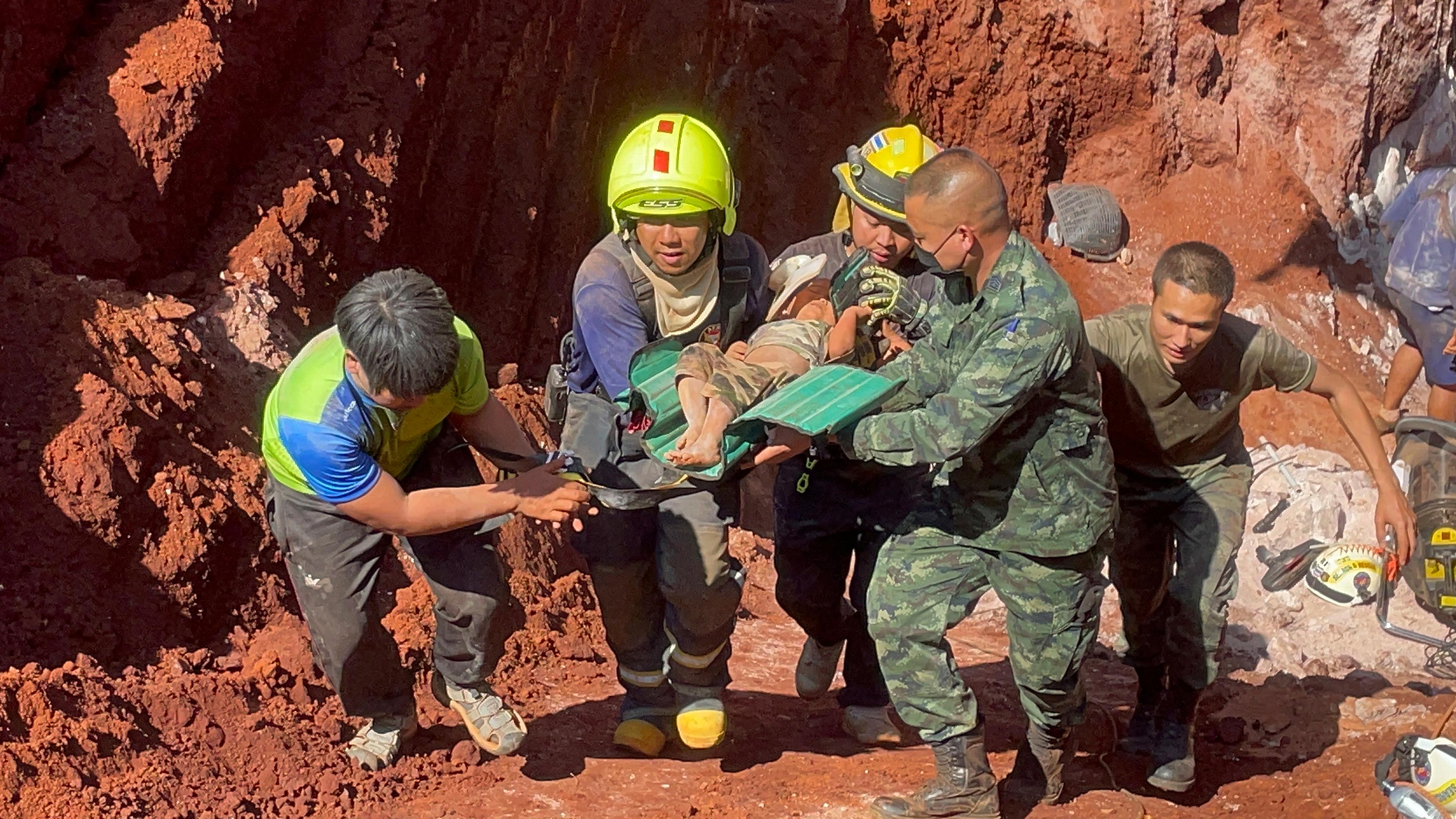 Nach einer nächtlichen Rettungsaktion tragen Rettungskräfte und Militärs ein einjähriges Kind aus einem tiefen Loch in der nordthailändischen Provinz Tak, aufgenommen am 07.02.2023