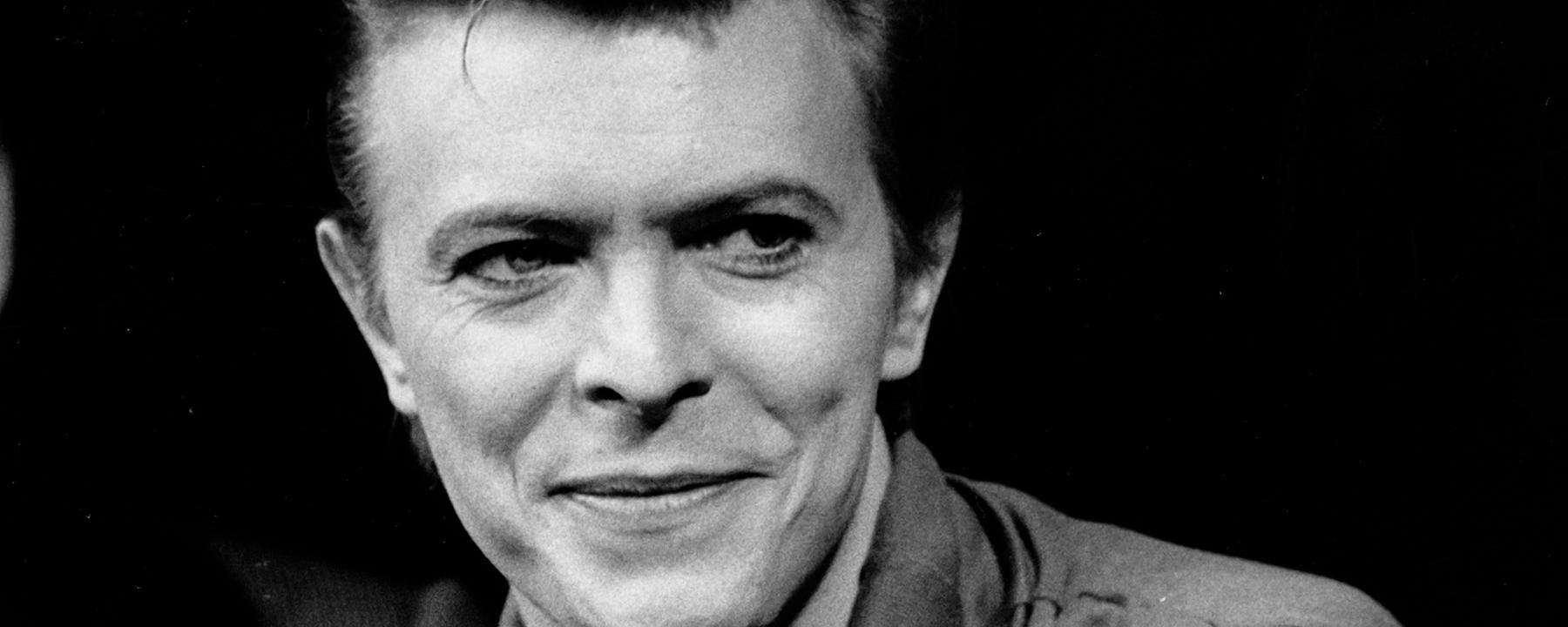 "The Day the Rock Star Died: David Bowie": Schwarz-Weiß-Portrait von David Bowie in einer Interview-Situation. Er blickt rechts an der Kamera vorbei.