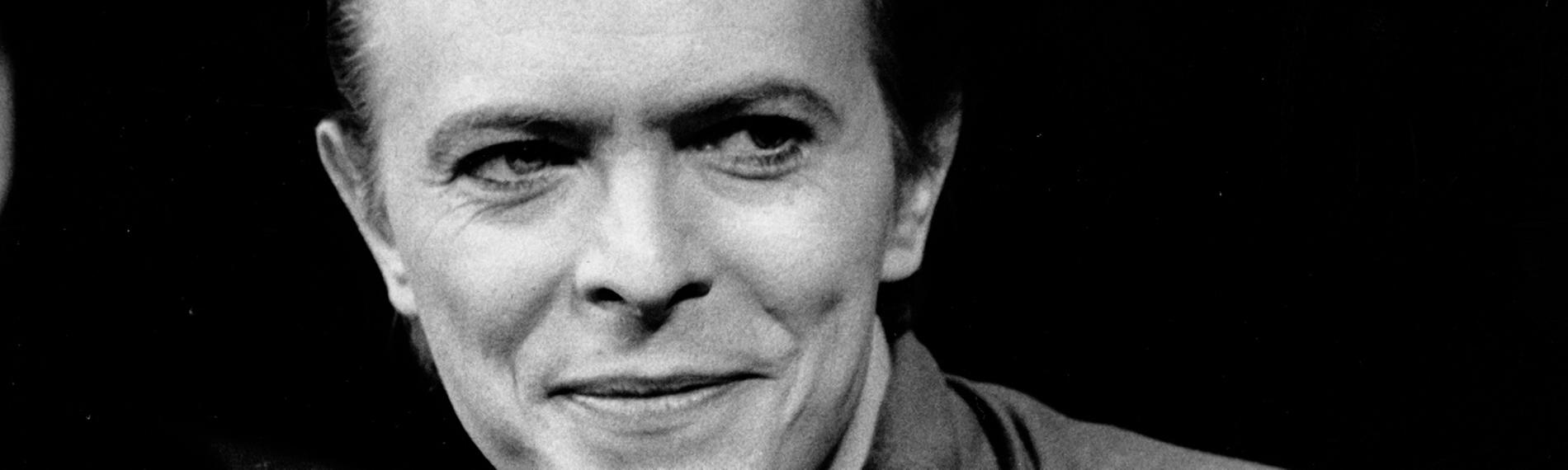"The Day the Rock Star Died: David Bowie": Schwarz-Weiß-Portrait von David Bowie in einer Interview-Situation. Er blickt rechts an der Kamera vorbei.