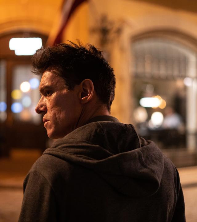 "The Good Neighbor": Nahaufnahme: Robert (Jonathan Rhys Meyers) steht von der Kamera abgekehrt und mit finsterem Blick in nächtlicher Straße.