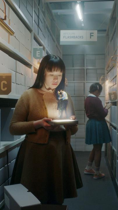 "The Ordinaries": Paula (Fine Sendel) steht im Gang eines Archivs und schaut auf ein Hologramm, welches sie in ihren Händen hält.  