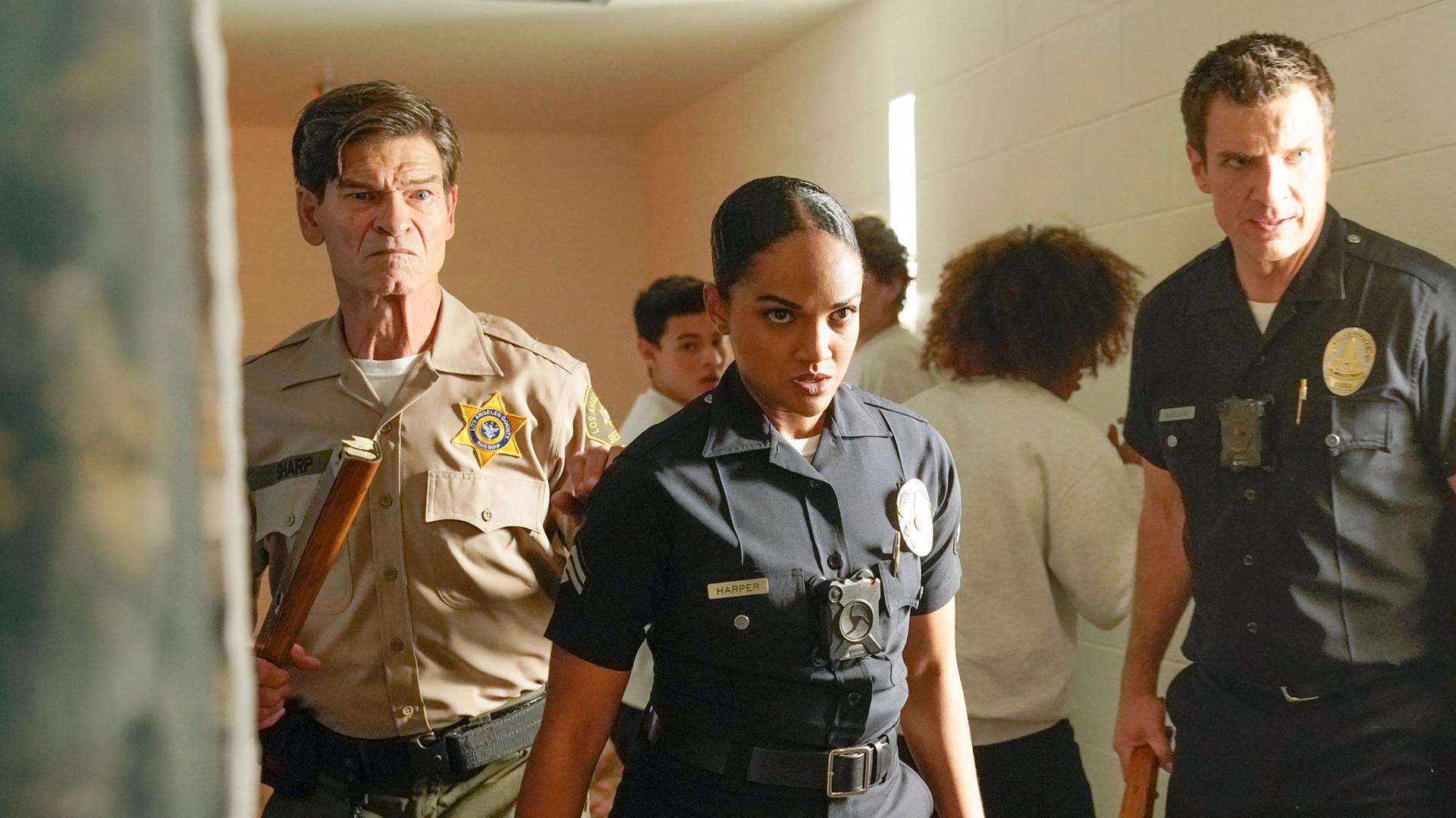 "The Rookie - Unter Druck": Nyla Harper (Mekia Cox), John Nolan (Nathan Fillion), und Deputy Sharp (Don Swayze) stehen, mit Holzstuhlbeinen bewaffnet, im Gang des Gefängnisses.