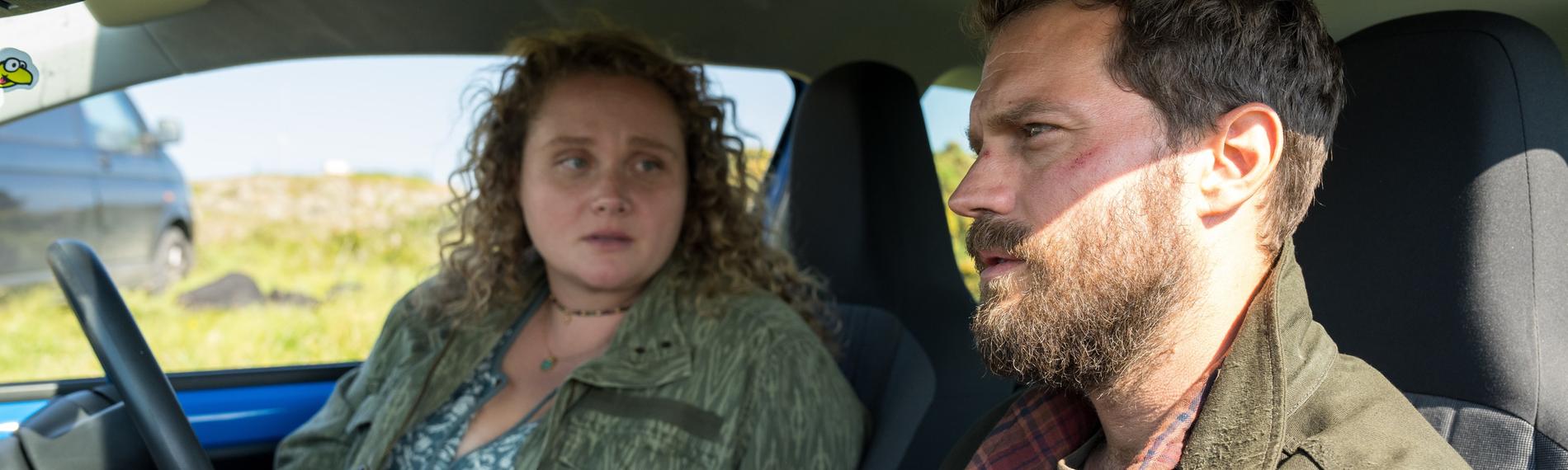 "The Tourist - Irisches Blut: Die Kinder von Lir": Elliot (Jamie Dornan) und Helen (Danielle Macdonald) sitzen in einem Kleinwagen und unterhalten sich.