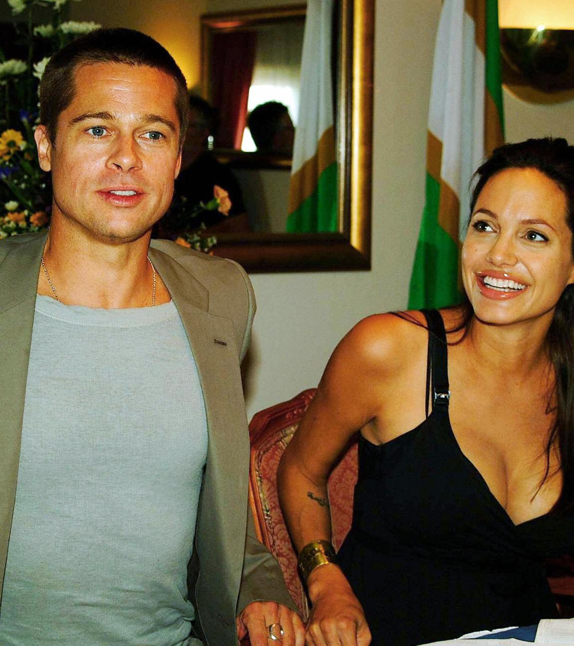 Brad Pitt und Angelina Jolie sitzen nebeneinander an einem Esstisch.