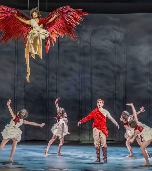 Bühnenszene: Fün Personen tanzen auf der Bühne. Ein Engel schwebt über ihnen.