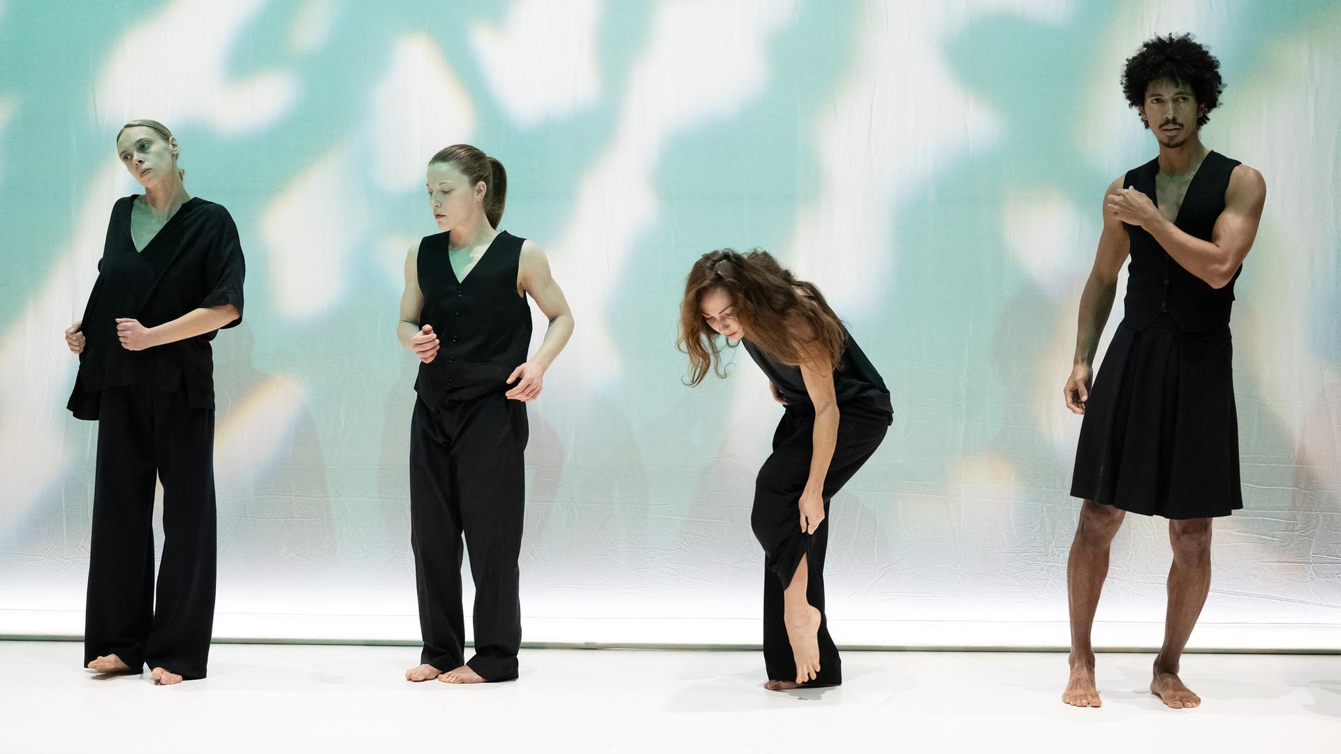 Bühnenszene: Tänzerinnen und Tänzer die schwarzeTrikots tragen, tanzen auf der Bühne.