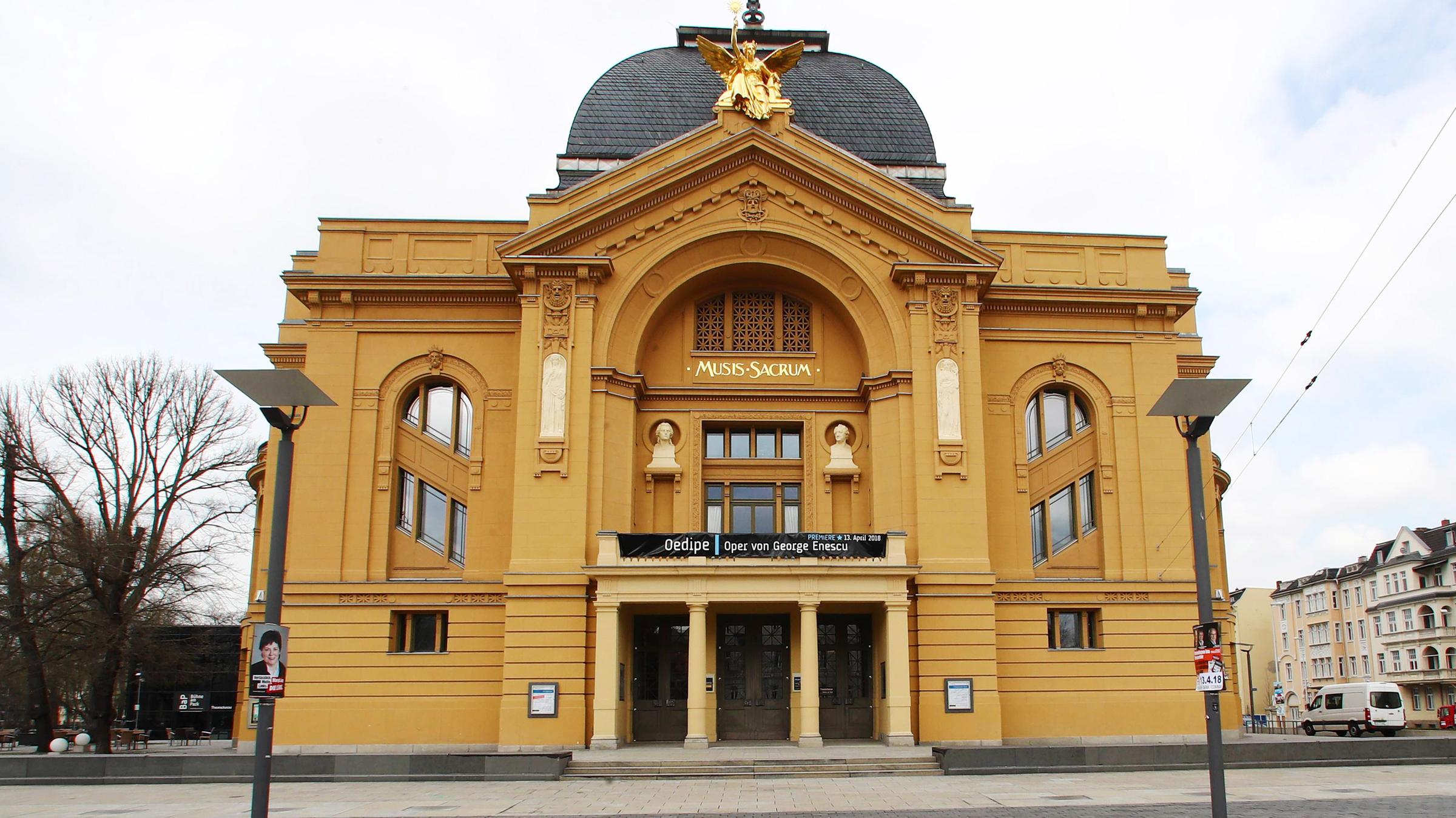Außenansicht des Theater  Altenburg Gera bei Sonnenschein. Im Vordergrund steht der Intendant des Theaters Kay Kuntze und die Schauspielerin Vidina Popov.