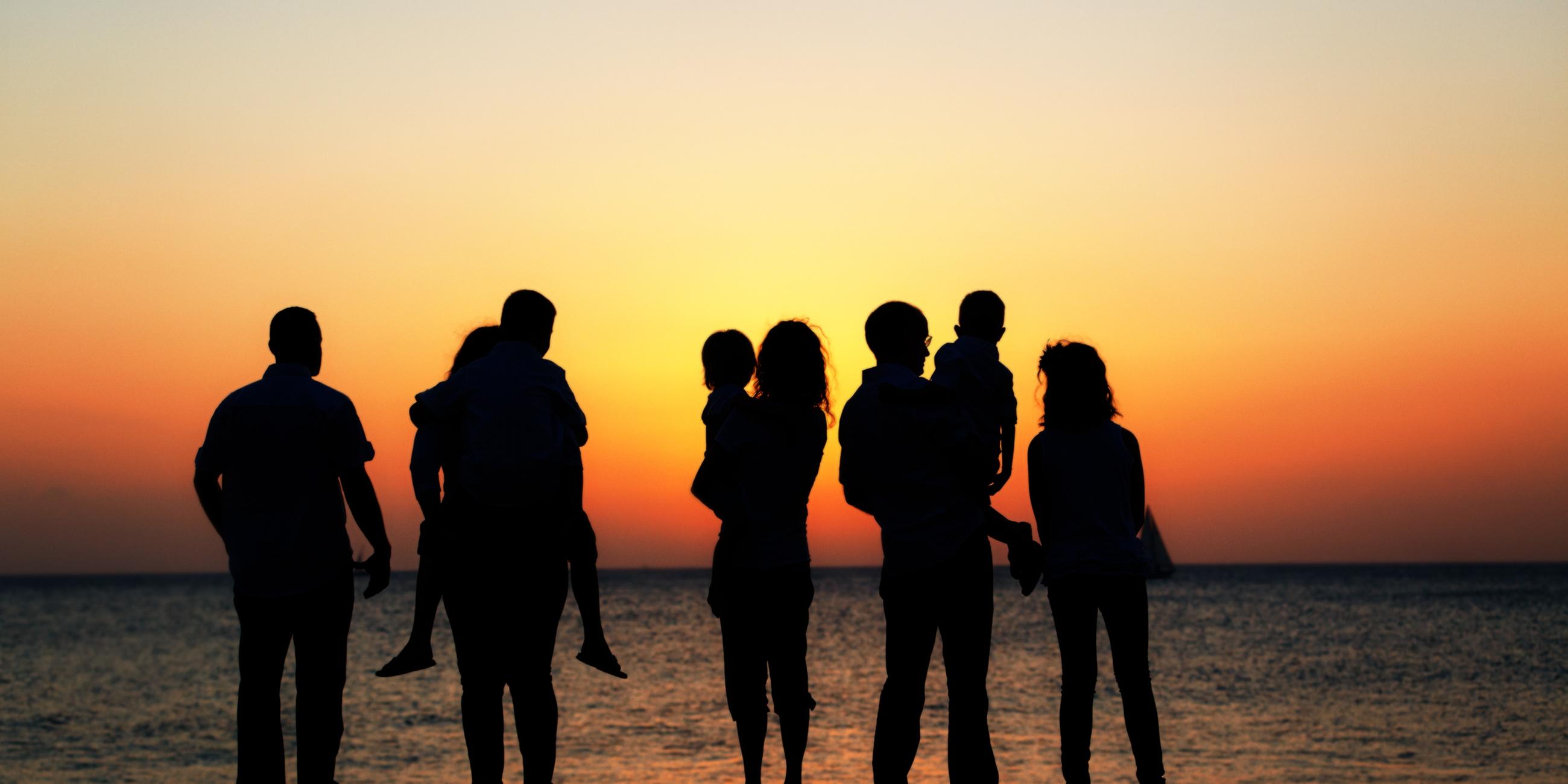 Silhuette einer Mehrgenerationen-Familie im Sonnenuntergang