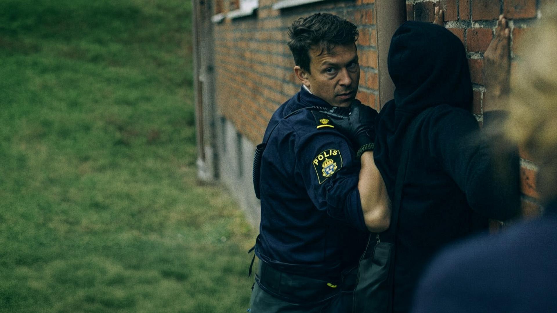 "Thin Blue Line - In die Enge getrieben" - Verdächtige werden an einer Wand dursucht und festgenommen.