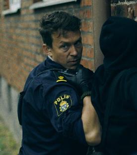 "Thin Blue Line - In die Enge getrieben" - Verdächtige werden an einer Wand dursucht und festgenommen.