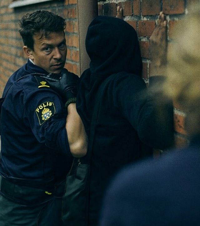 "Thin Blue Line - In die Enge getrieben" - Verdächtige werden an einer Wand dursucht und festgenommen.