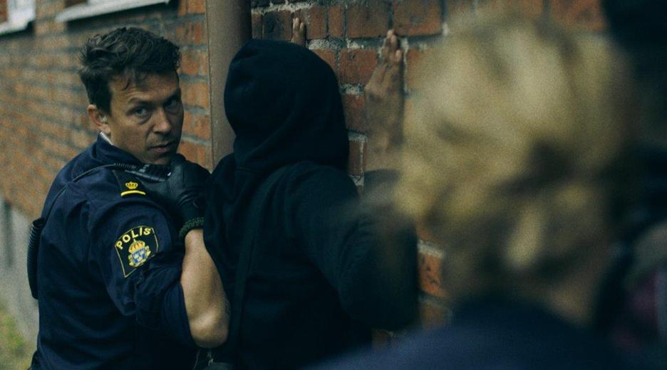 "Thin Blue Line - In die Enge getrieben" - Verdächtige werden an einer Wand dursucht und festgenommen.