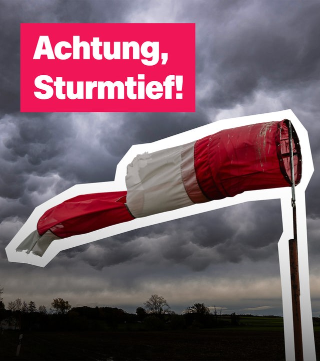 Eine Windfahne weht im Wind, am Himmel sind dunkle Wolken. 
