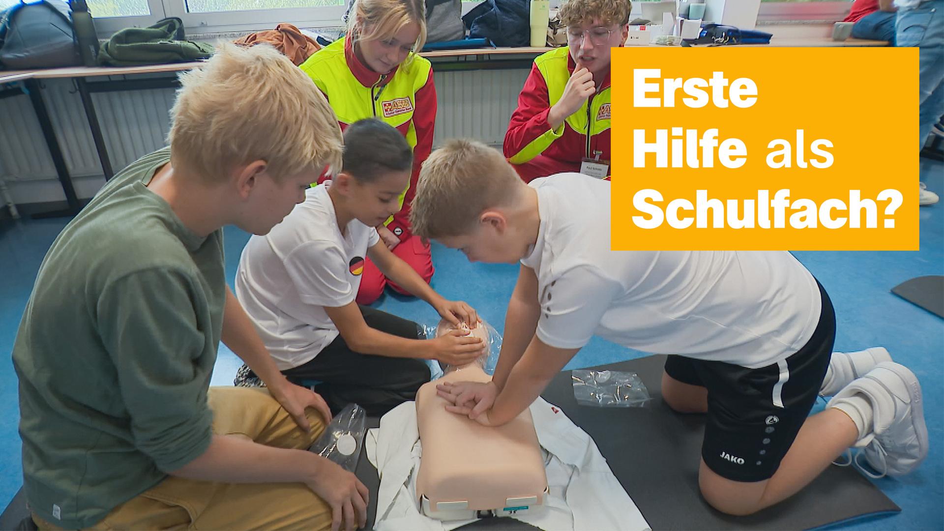 Kinder üben Erste Hilfe an einer Puppe. 