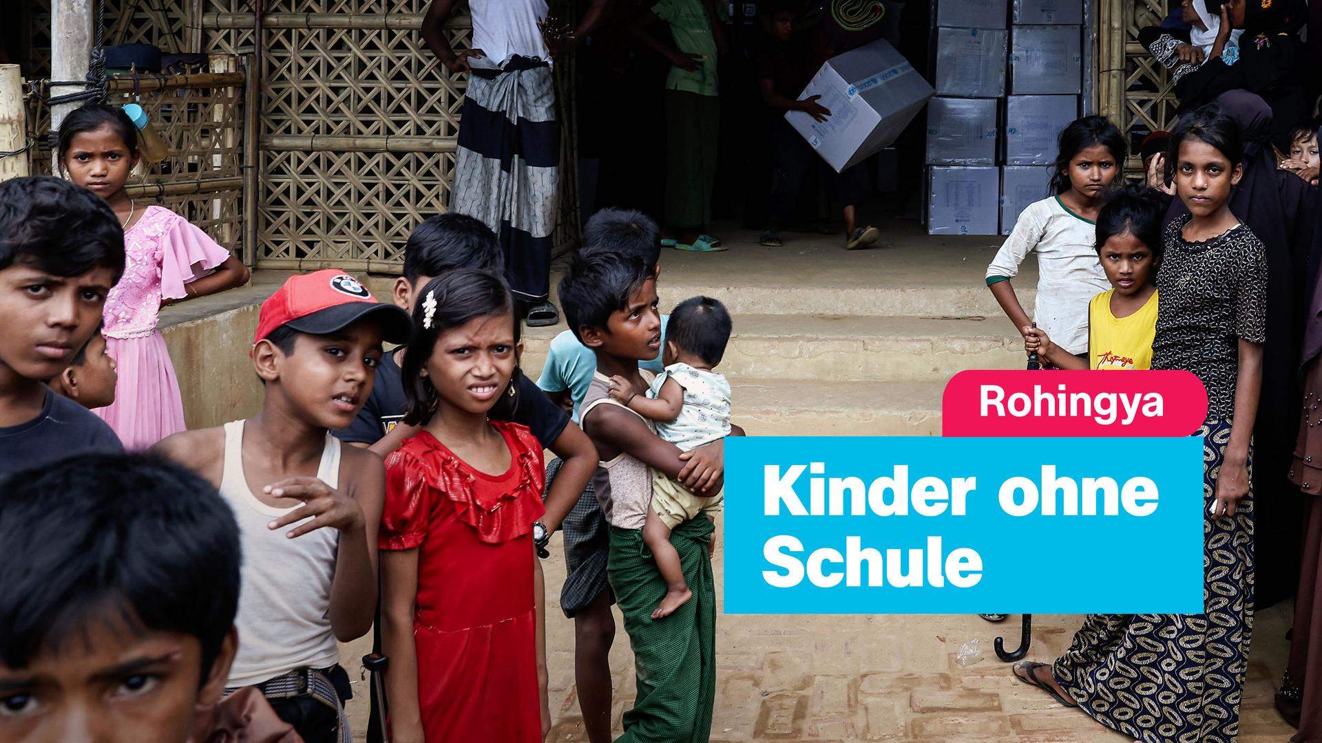 Mehrere Kinder in einem Geflüchtetenlager schauen in die Kamera. 