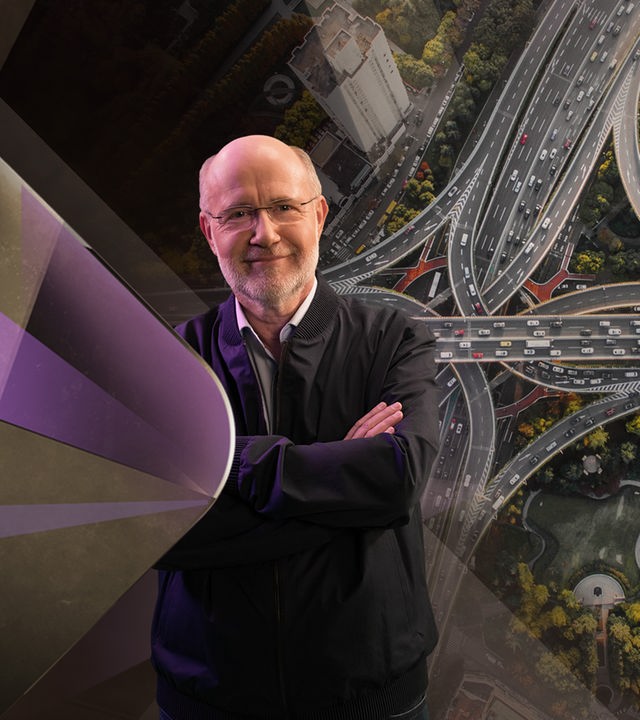 Harald Lesch steht vor Autobahnkreuz.