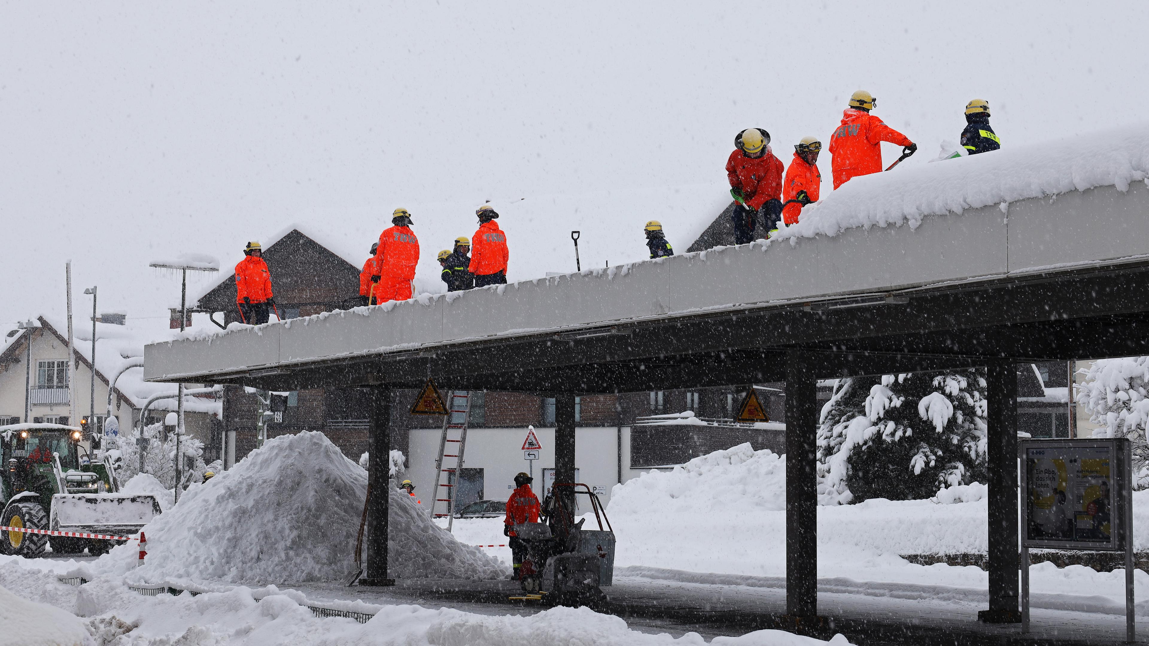 Einsatzkräfte des Technischen Hilfswerks (THW) befreien das Bahnhofsdach im Bahnhof Oberstaufen von der Schneelast