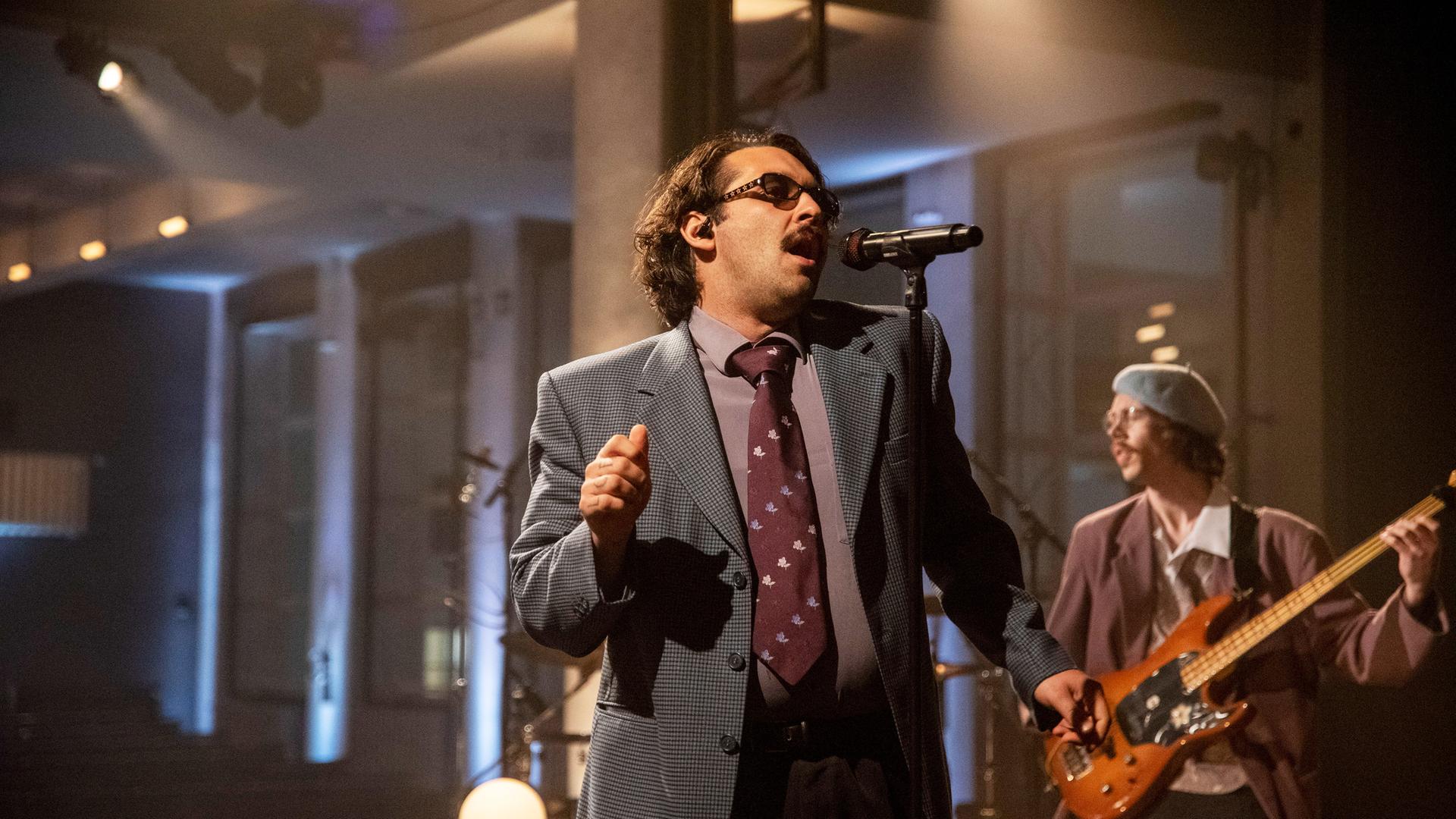 Der Sänger der Band Tiavo singt in ein Mikrofon.