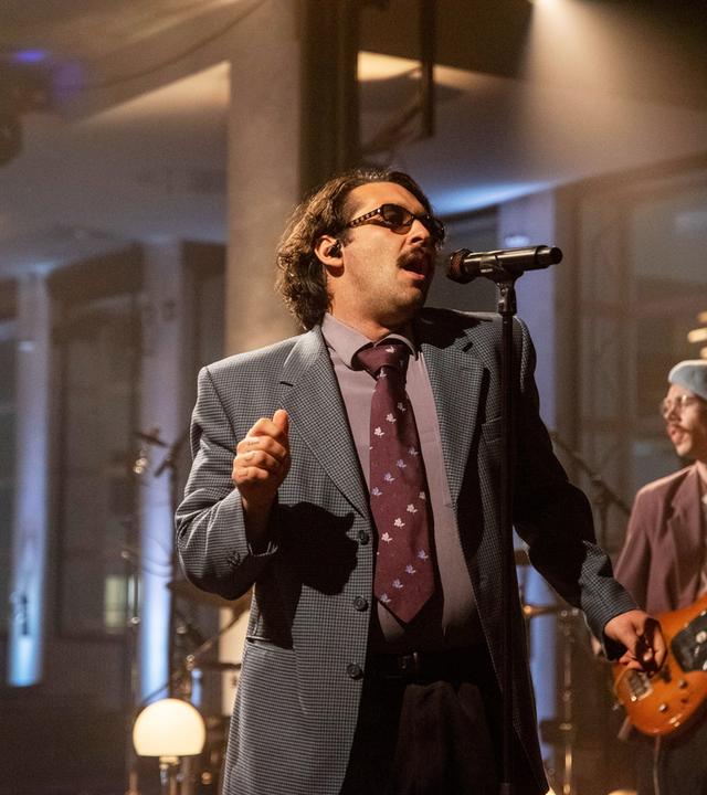 Der Sänger der Band Tiavo singt in ein Mikrofon.