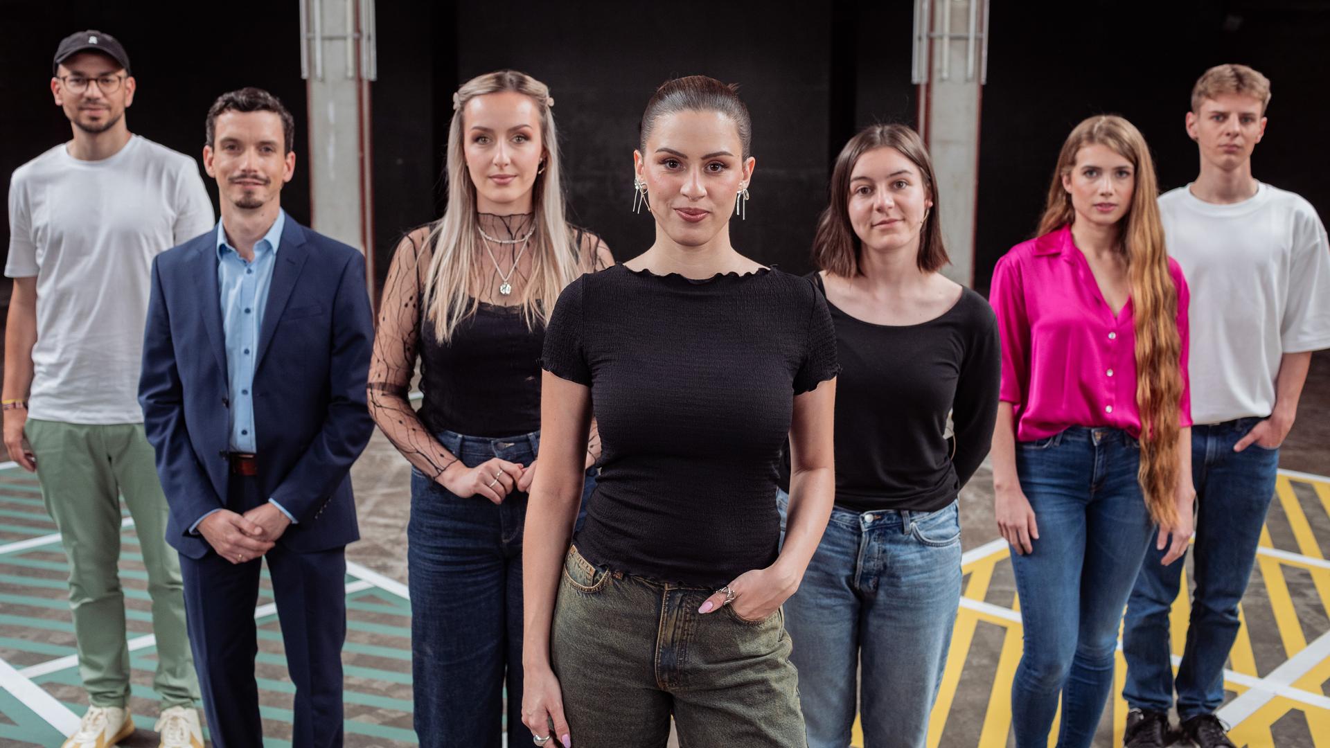 Moderatorin Salwa Houmsi steht mit ihren sechs Gästen auf dem 13-Fragen-Spielfeld.