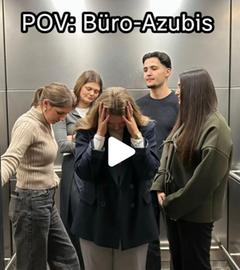 Eine Gruppe junger Menschen im Aufzug, die junge Frau im Vordergrund fasst sich an den Kopf und schaut auf den Boden