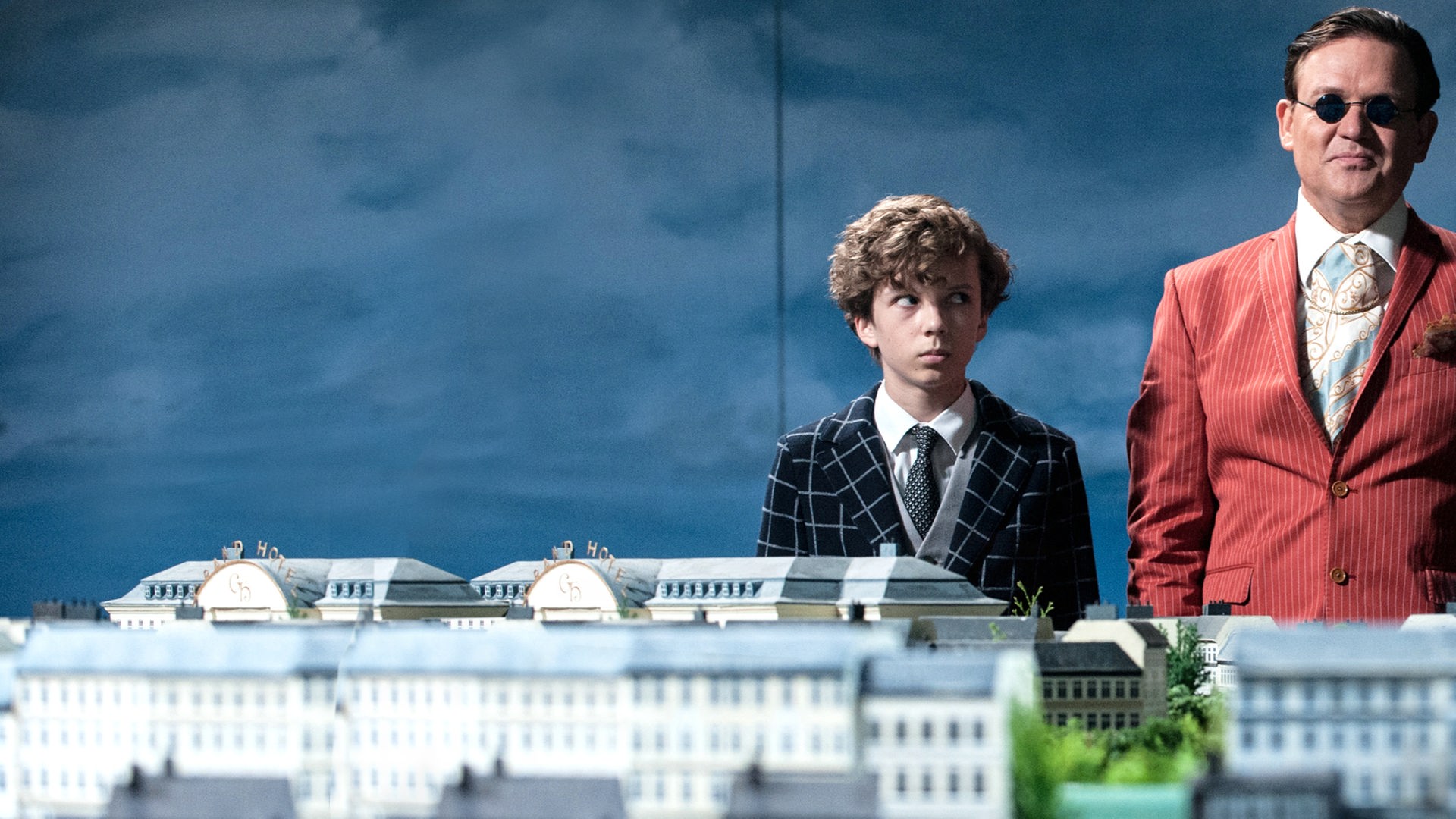 Baron Lefuet (Justus von Dohnányi, r.) weiht Timm (Arved Friese, l.) in seinen perfiden Plan ein. Er will mit Hilfe seines Lachens die Herzen und Geldbörsen der Menschen öffnen.