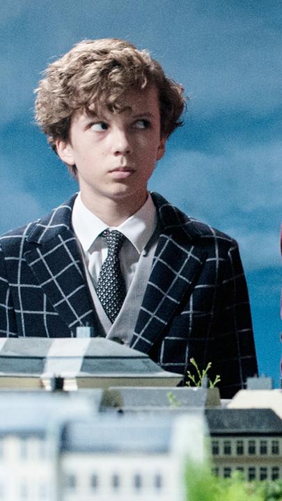 Baron Lefuet (Justus von Dohnányi, r.) weiht Timm (Arved Friese, l.) in seinen perfiden Plan ein. Er will mit Hilfe seines Lachens die Herzen und Geldbörsen der Menschen öffnen.