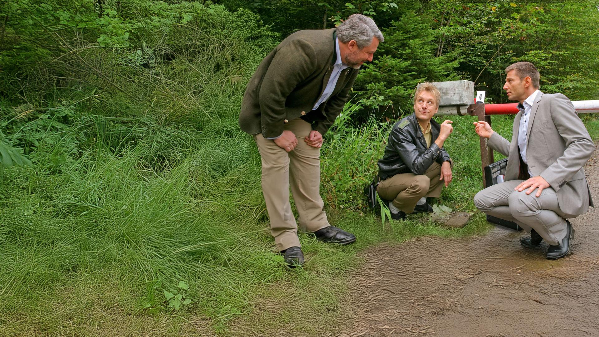 "Die Rosenheim-Cops: Tod am Schlagbaum": Kommissar Stadler (Dieter Fischer), Polizist Mohr (Max Müller) und Kommissar Hansen (Igor Jeftic) untersuchen Spuren an einem Schlagbaum im Wald.
