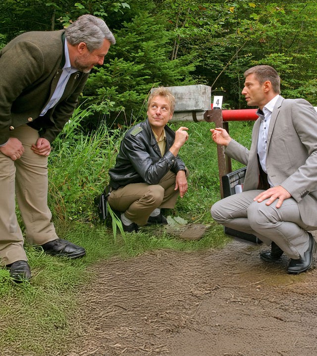"Die Rosenheim-Cops: Tod am Schlagbaum": Kommissar Stadler (Dieter Fischer), Polizist Mohr (Max Müller) und Kommissar Hansen (Igor Jeftic) untersuchen Spuren an einem Schlagbaum im Wald.