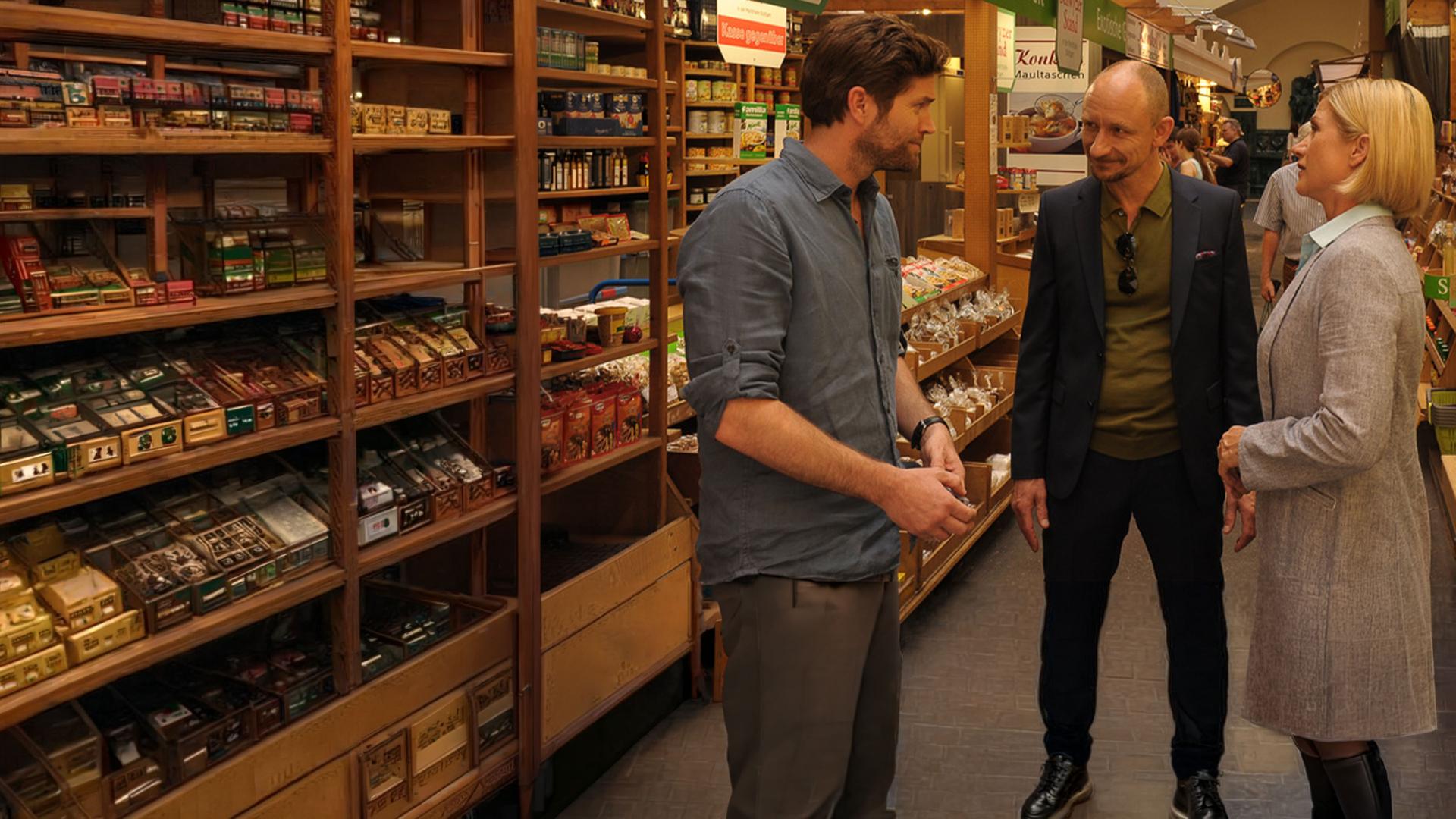 "SOKO Stuttgart - Tod in der Markthalle": Eingekeilt zwischen Martina Seiffert (Astrid M. Fünderich) und Jo Stoll (Peter Ketnath) steht Erik Setzkorn (Michael Schenk) in der Markthalle Rede und Antwort.