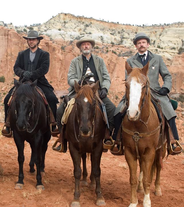 Doc Potter (Alan Tudyk) Dan Evans (Christian Bale), Ben Wade (Russell Crowe), Byron McElroy (Peter Fonda) und Grayson Butterfield (Dallas Roberts) nebeneinander auf ihren Pferden.