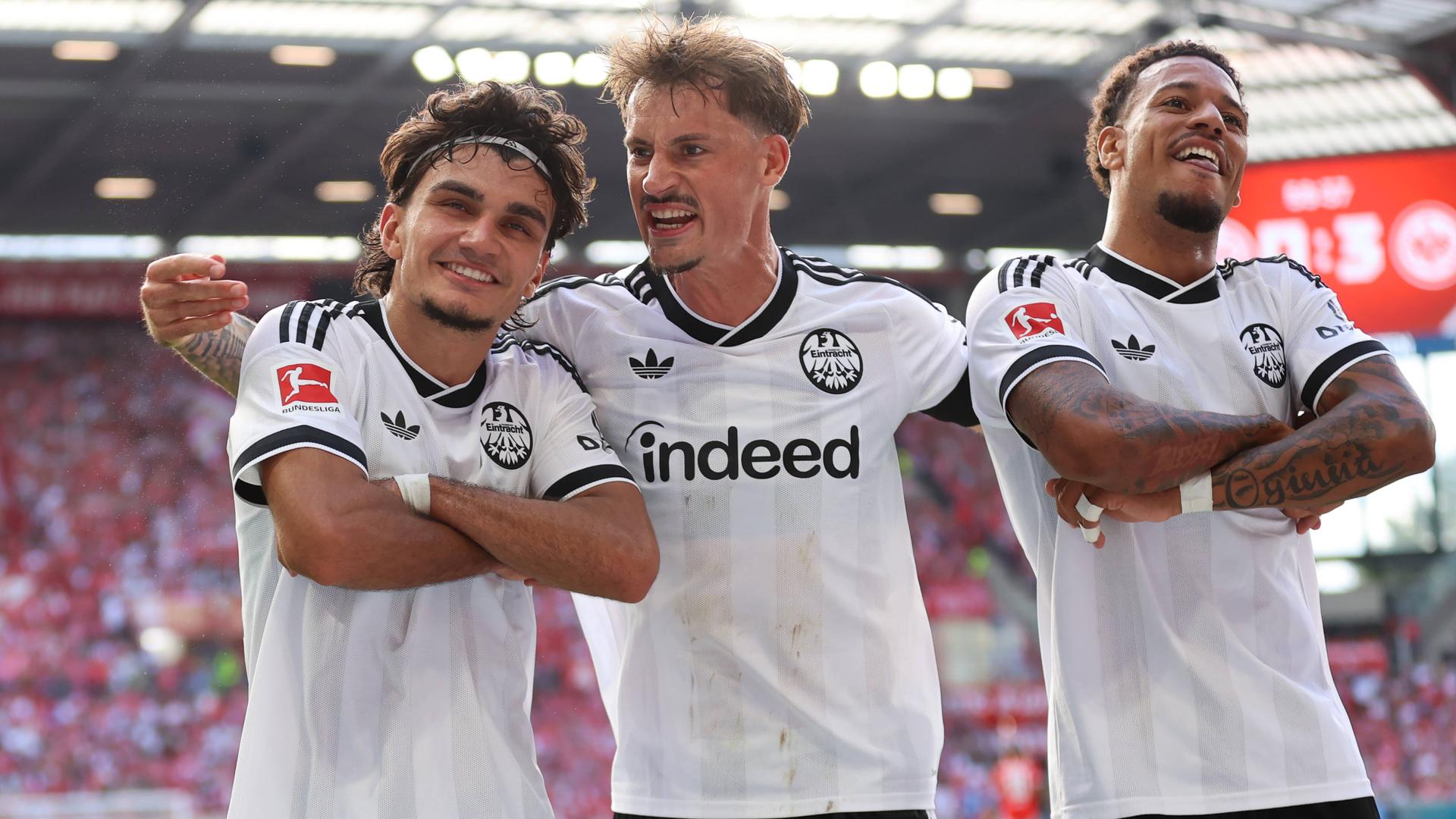 Frankfurts offensiver Mittelfeldspieler Can Uzun jubelt zusammen mit seinen Teamkameraden Robin Koch und Jeremiaha Maluze nach seinem Treffer zum 3:0