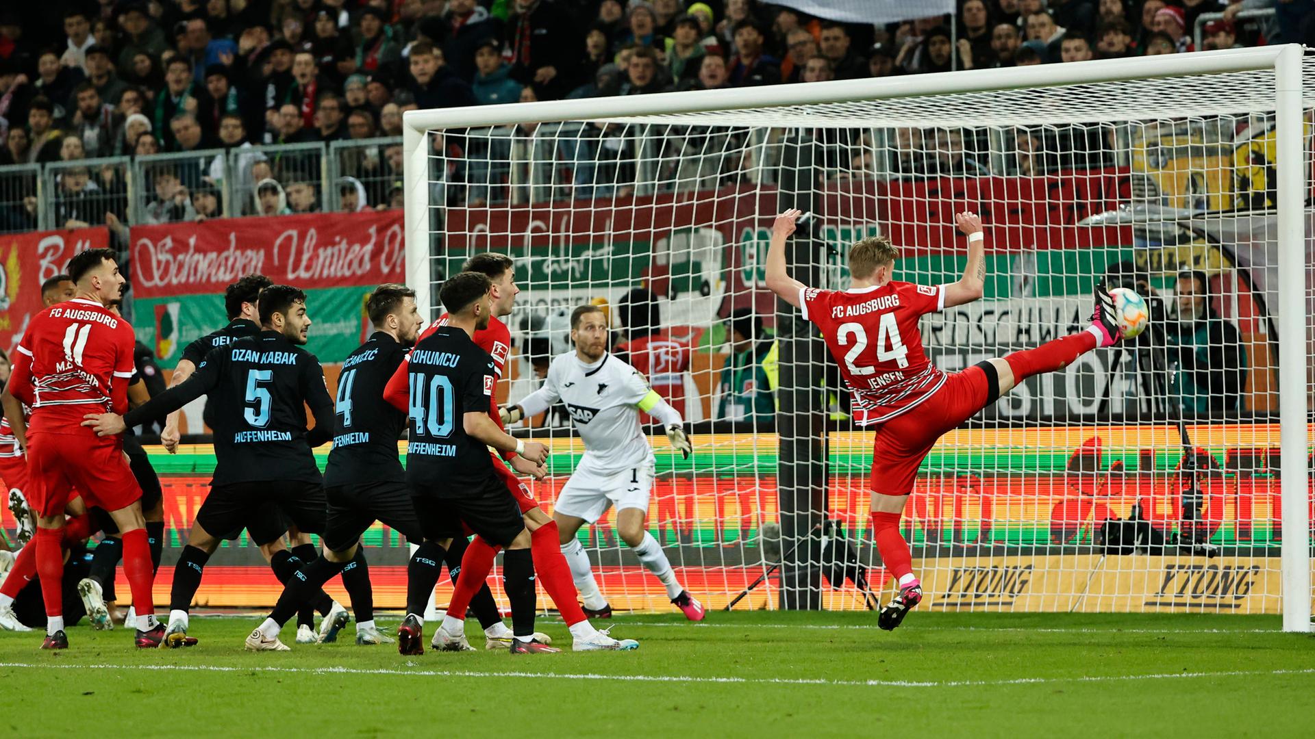 17. Februar 2023  Hans Fredrik Jensen (1. R) aus Augsburg punktet während des Fußballspiels zwischen dem FC Augsburg und der TSG Hoffenheim in Augsburg