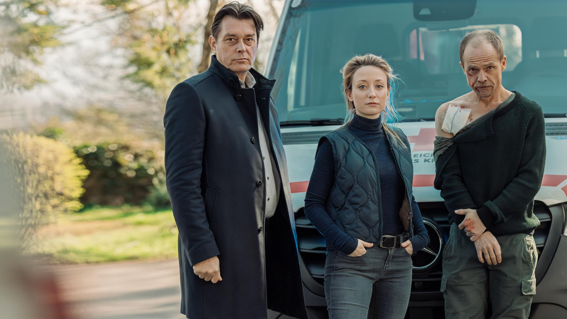 "Die Toten vom Bodensee - Die Messias": Micha Oberländer (Matthias Koeberlin), Luisa Hoffmann (Alina Fritsch) und Thomas Komlatschek (Hary Prinz) stehen zusammen vor einem Notarztwagen. Micha Oberländer (Matthias Koeberlin) ist verletzt.