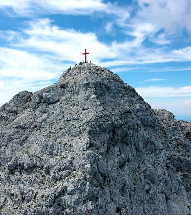 Steiniger Berggipfel mit Wanderern.