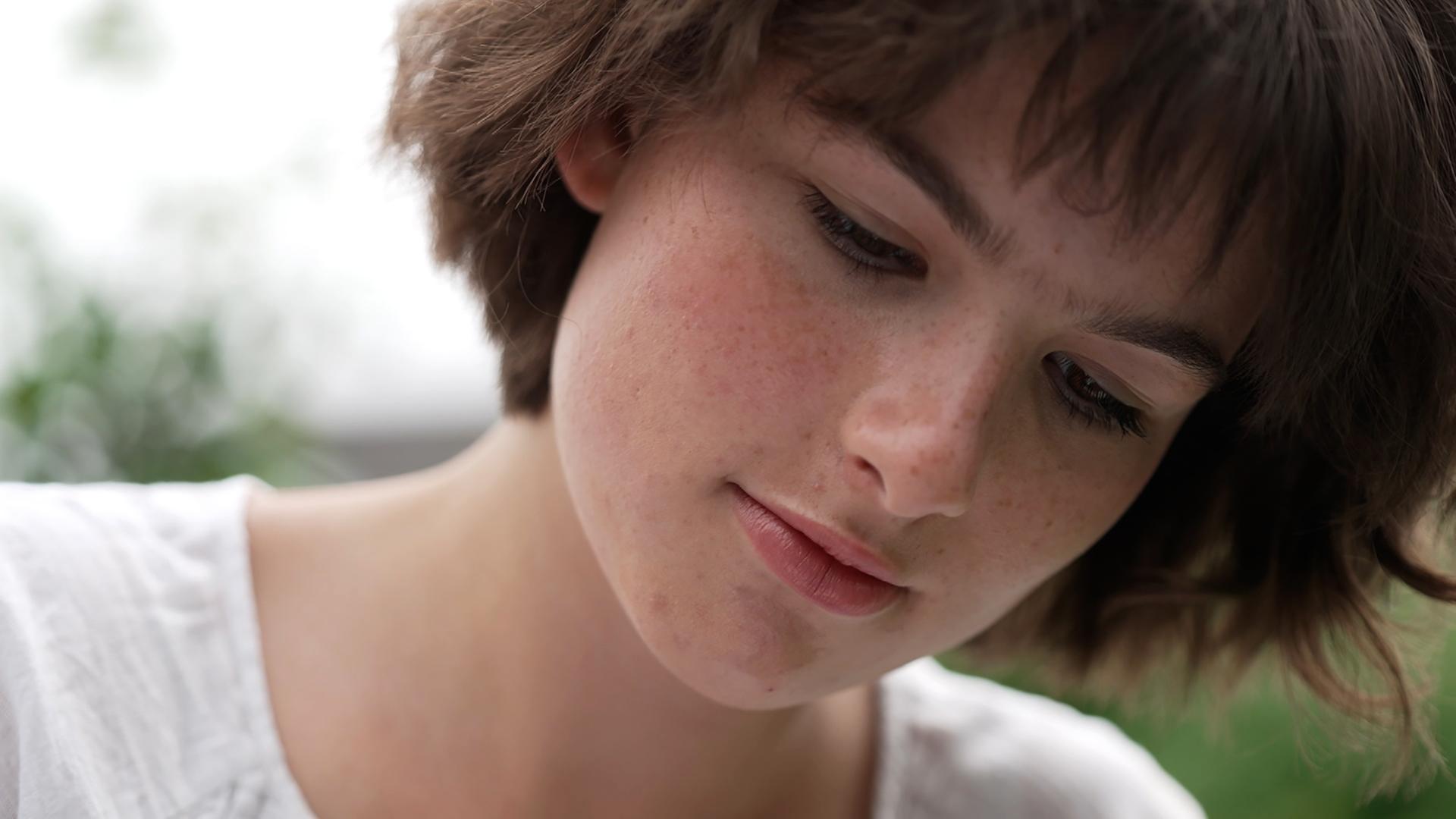 Eine Nahaufnahme einer jungen Frau, die nach unten schaut