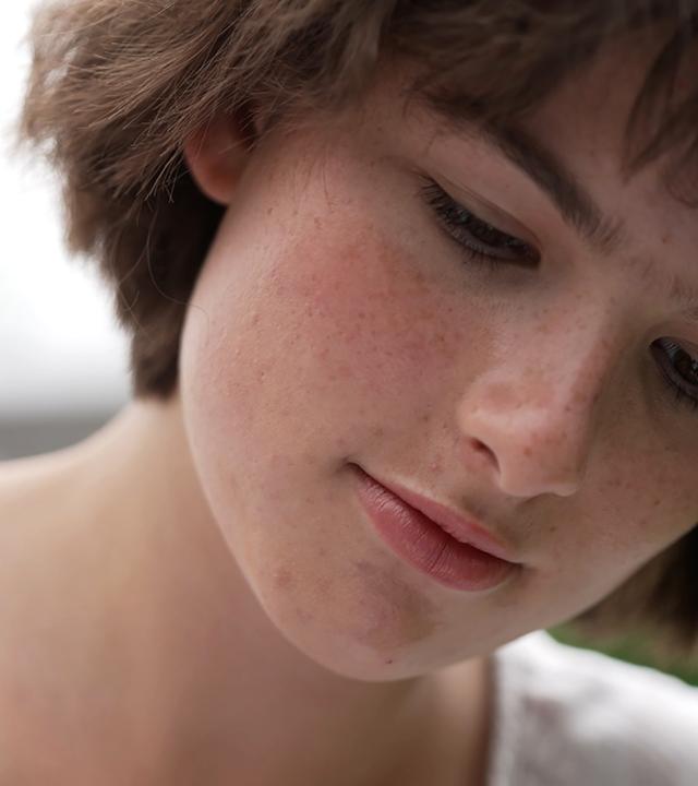 Eine Nahaufnahme einer jungen Frau, die nach unten schaut