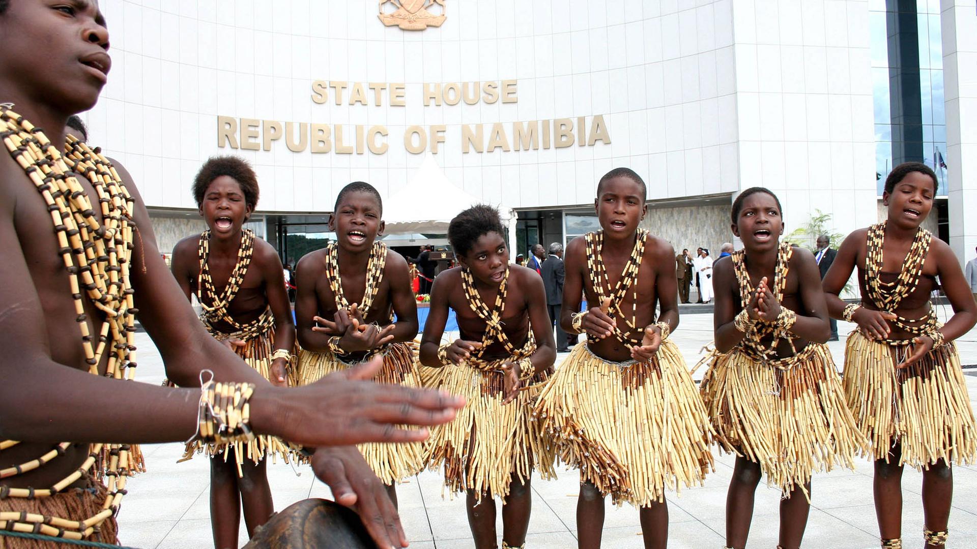 Tänzer in Baströcken und Schmuck